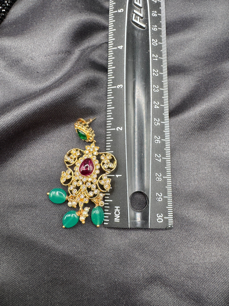 A bunch of black beads with an uncut stone pendant with matching earrings